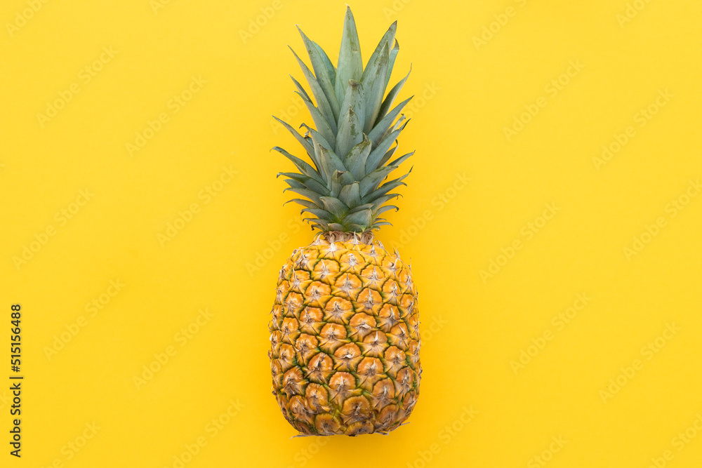 Ripe pineapple on a yellow background
