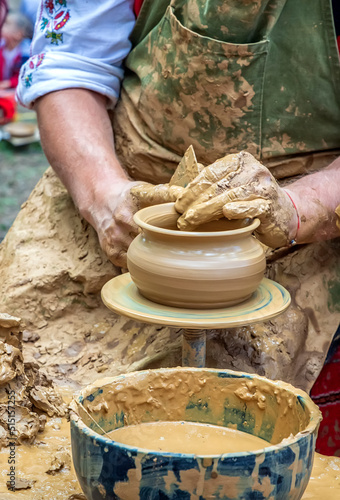 A master of pottery craftsmanship teaches a child who wants to learn how to sculpt a jug. Pottery master class.