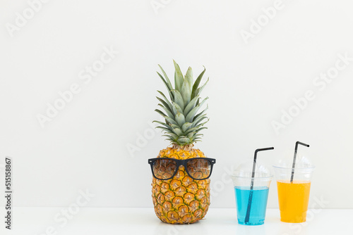 Ripe pineapple in sunglasses and cocktails on a white background. Summer vacation. Hello summer