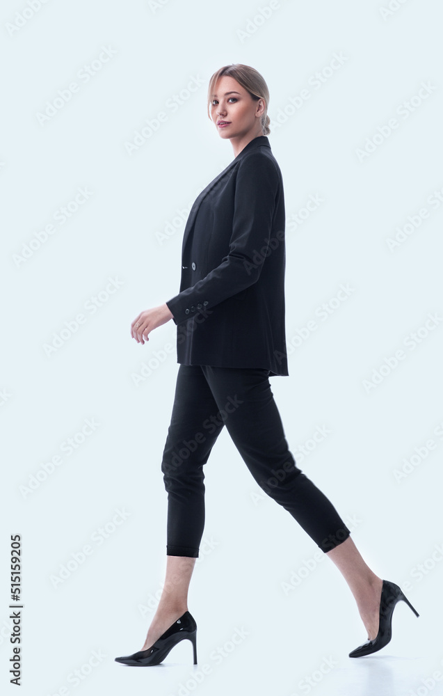 side view. a young businesswoman is confidently moving forward side view. a young businesswoman is confidently moving forward
