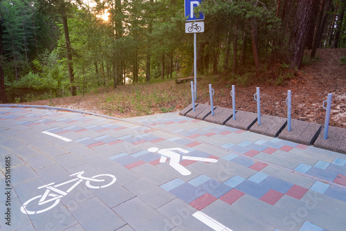 Bicycle path, bike parking and walkpath in city natural park. Infrastructure for cyclists and pedestrians in urban environment photo