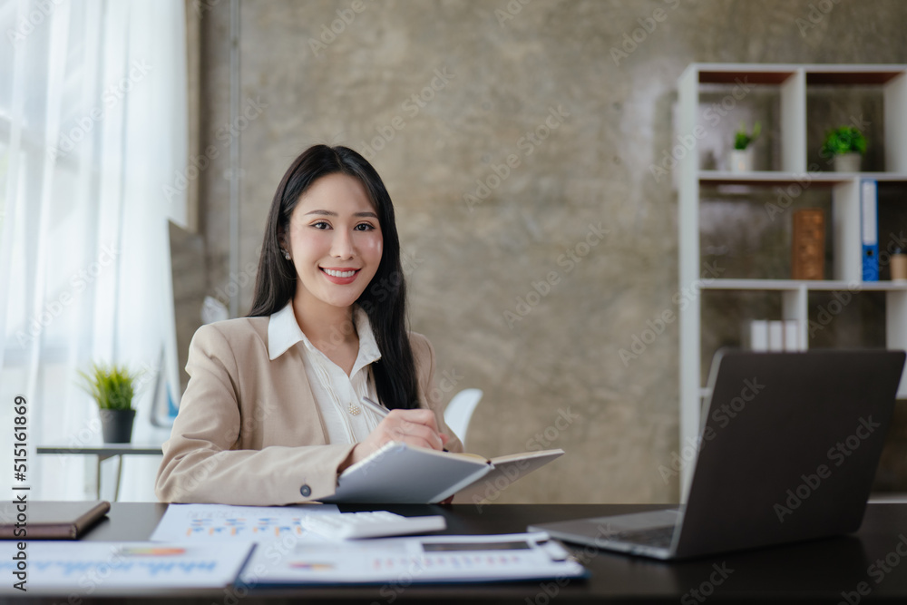 Young business woman is working on paperworks and laptop in office space. Young business woman is working on paperworks and laptop in office space.