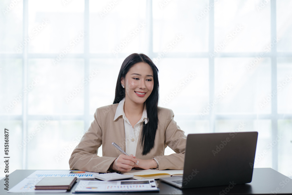 Young business woman is working on paperworks and laptop in office space. Young business woman is working on paperworks and laptop in office space.
