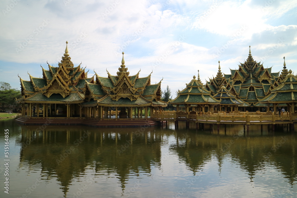 Two green-roofed, oriental-style minaret buildings on the lake are connected by a golden bridge Two green-roofed, oriental-style minaret buildings on the lake are connected by a golden bridge