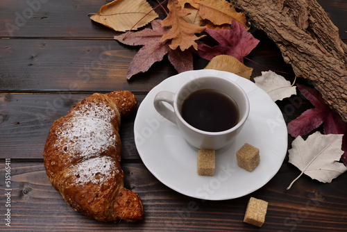 Cornetto e caffè a colazione in autunno photo
