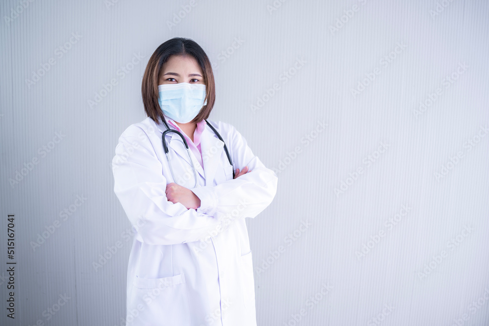 Photo of an Asian female doctor smile and look at the camera The back is a white background. Photo of an Asian female doctor smile and look at the camera The back is a white background.