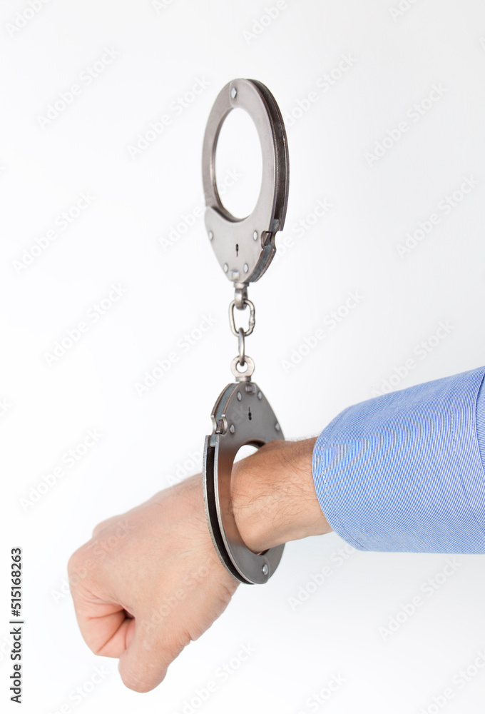 hand buckled in handcuffs, on an isolated white background hand buckled in handcuffs, on an isolated white background