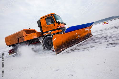 Obraz na plátně Snowplow truck cleans runway on airfield during snowfall