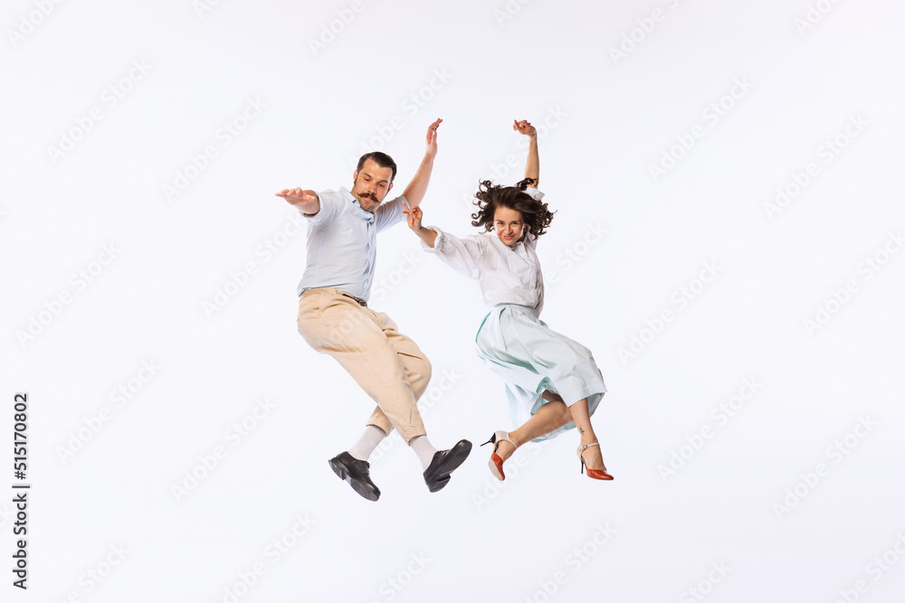 Portrait of young beautiful couple, man and woman, dancing, jumping isolated over white studio background Portrait of young beautiful couple, man and woman, dancing, jumping isolated over white studio background