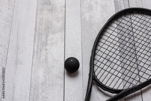 Black squash racket and ball on grey court. Horizontal sport theme poster, greeting cards, headers, website and app