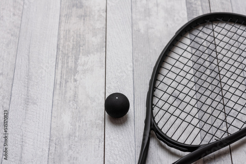 Black squash racket and ball on grey court. Horizontal sport theme poster, greeting cards, headers, website and app photo