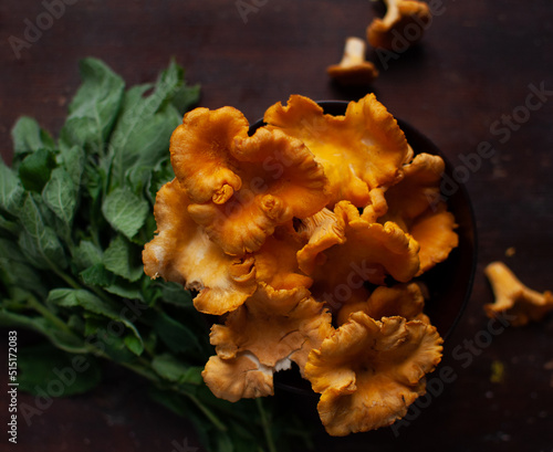 chanterelles mushroom in wooden bowl  with mint on brown wooden board cooking ingredients