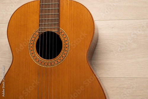 Classical guitar body close up, on a light wood background with copy space. 
