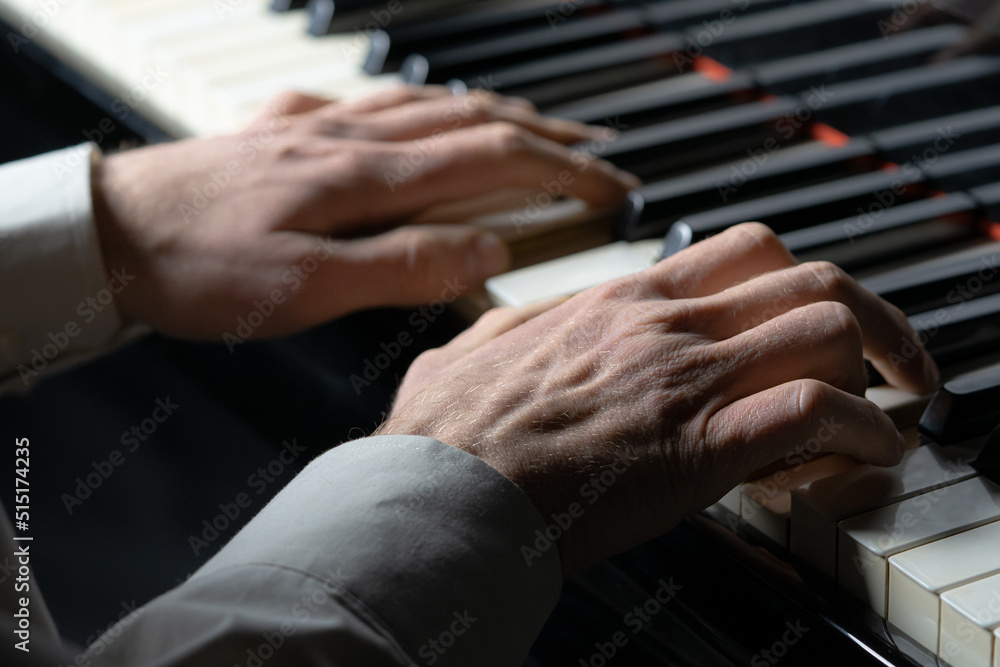Pianist man plays music on the piano. Musician touches the white and black keys of string instrument with his fingers creating a musical melody. Screensaver for a music school. Man hands close up. Pianist man plays music on the piano. Musician touches the white and black keys of string instrument with his fingers creating a musical melody. Screensaver for a music school. Man hands close up.