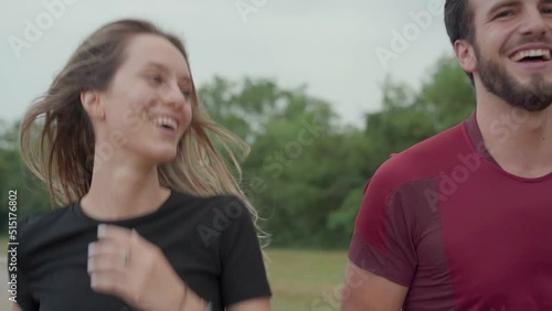 Smiling couple running together outdoor in natural place, healthy lifestyle promotion, caucasian young adult man and woman. Athletic person training with instructor body, exercise and wellness concept