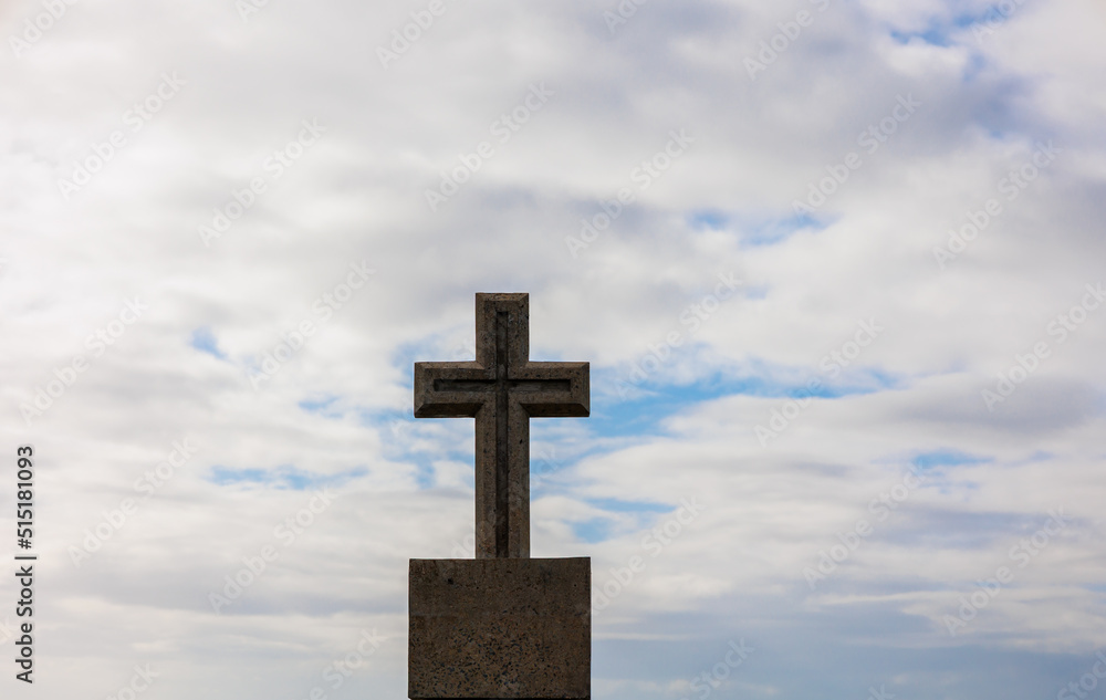 concrete cross with cloudy sky background