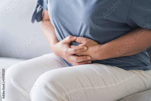 Woman suffering from stomachache sitting on the sofa at home. abdominal pain  Gastritis  Period  menstruation.