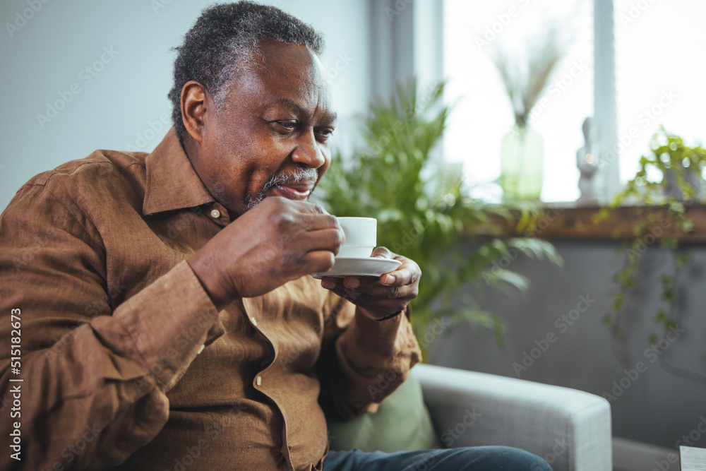 Shot of a senior man having a cup of coffee at home. Cropped shot of a happy senior man sitting and holding a cup of coffee while going through his financial budgets. Shot of a senior man having a cup of coffee at home. Cropped shot of a happy senior man sitting and holding a cup of coffee while going through his financial budgets.