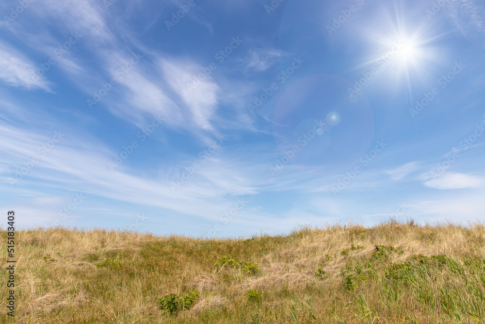 landscape of Baltic Sea dunes with white clouds on blue sky	in background