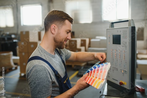 Funny portrait of typographer standing with color swatches at the printing manufacturing photo