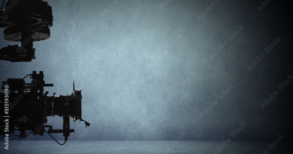 Digital video camera on set with dark concrete wall background ...