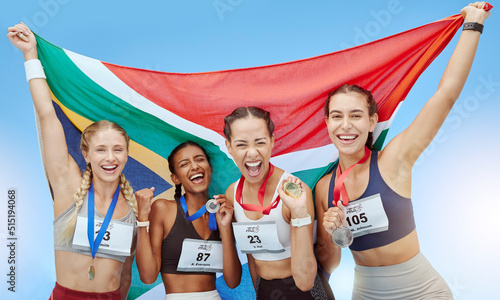 Portrait diverse group of female olympic athletes holding winners medals and African flag. Happy and proud champions of South Africa. Winning a medal for your country is an amazing achievement