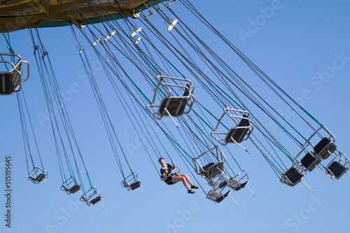 Teenage girl on chain swing carousel