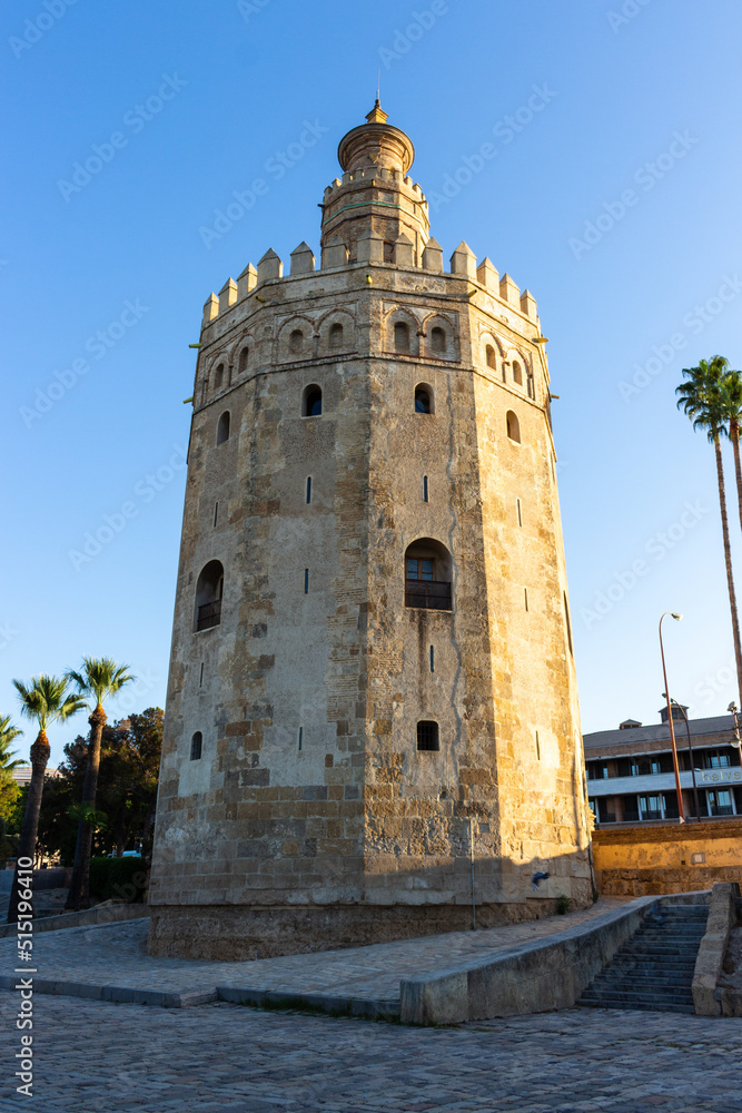 Seville, Spain, September 12, 2021: The Tower of Gold at the Quidalquivir in Sevilla. The Golden Tower is one of Seville's iconic landmarks. La Torre del Oro is a military observation tower.