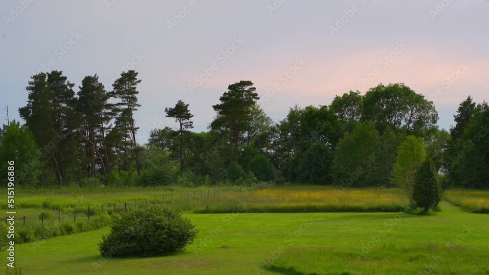 Mowed lawn of rural homestead with wild landscape behind, shadow timelapse Mowed lawn of rural homestead with wild landscape behind, shadow timelapse