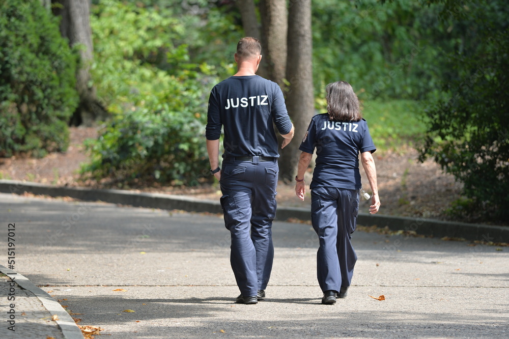 A female and a male german correctional officer in her uniforms walking through a park in Berlin-Germany on a warm summer day in her pause. A female and a male german correctional officer in her uniforms walking through a park in Berlin-Germany on a warm summer day in her pause.