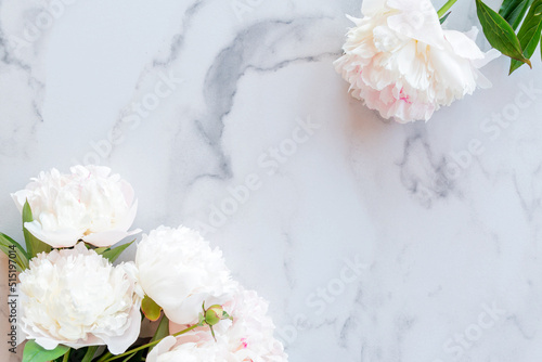 Fototapeta Naklejka Na Ścianę i Meble -  Template for a romantic greeting card with creamy peonies on a white marble background. Blossoming flowers on a white background. pink peonies on a white marble table, flat lay