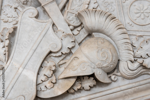 Close-up on ancient roman helmet carved in a decorated marble wall