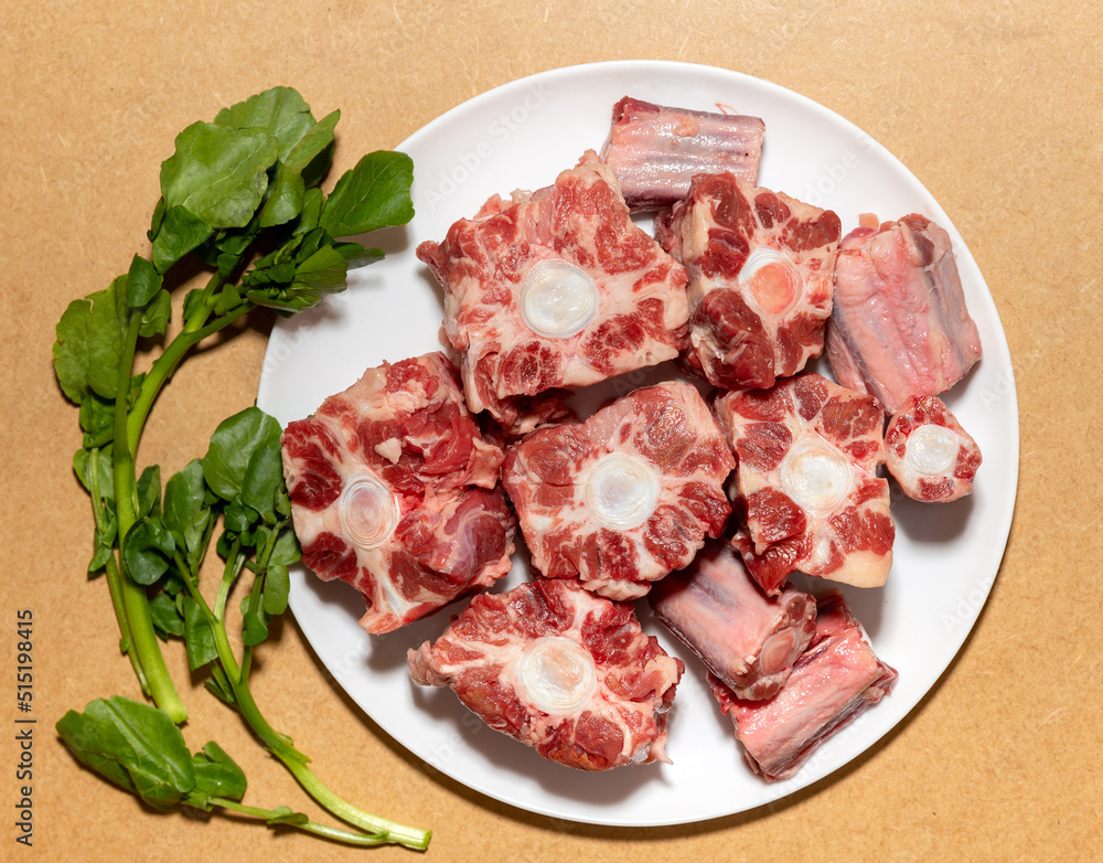 Oxtail Meat, typical Brazilian cuisine in top view. Raw beef with watercress. 