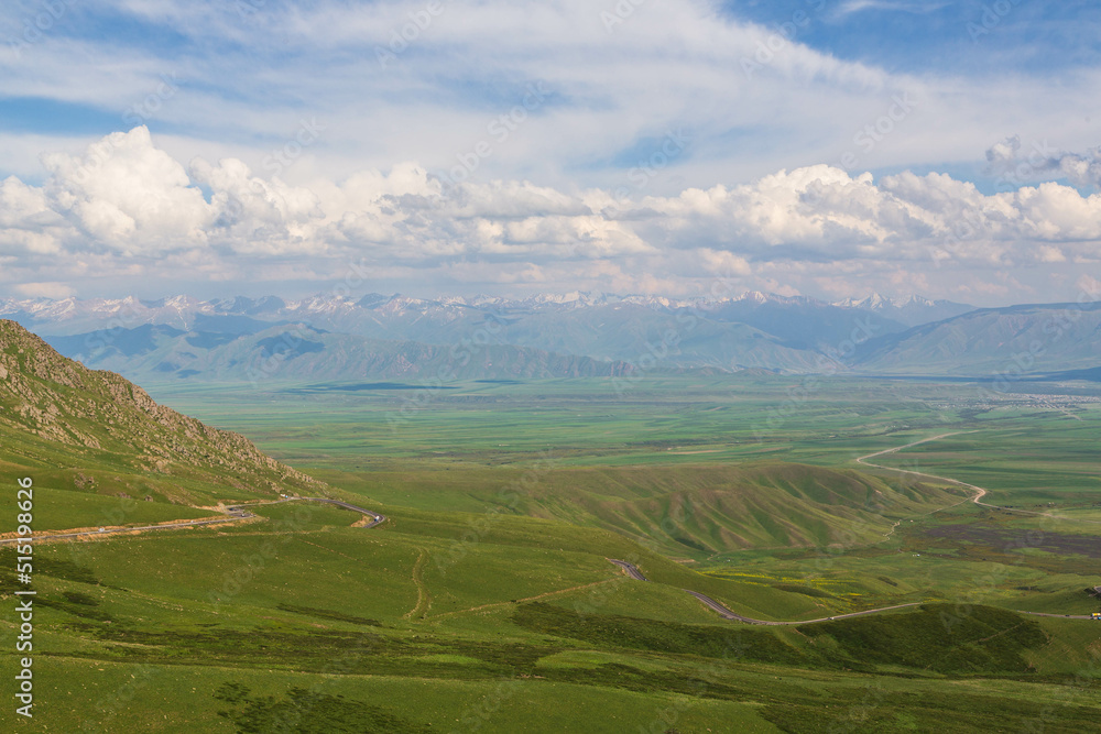Aerial view over the valley and Talas Ala-Too and Suusamyr-Too ranges in the clouds from Ala Bel pass. Kyrgyzstan