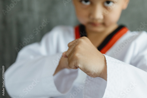 Asian boy clenching fists to practice taekwondo, Taekwondo martial art, selective focus detail on hand