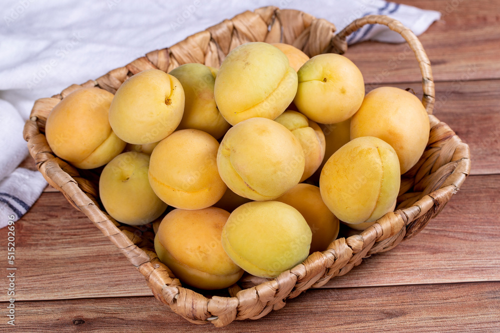 Apricots on wood background. A pile of fresh apricots in a basket. close up