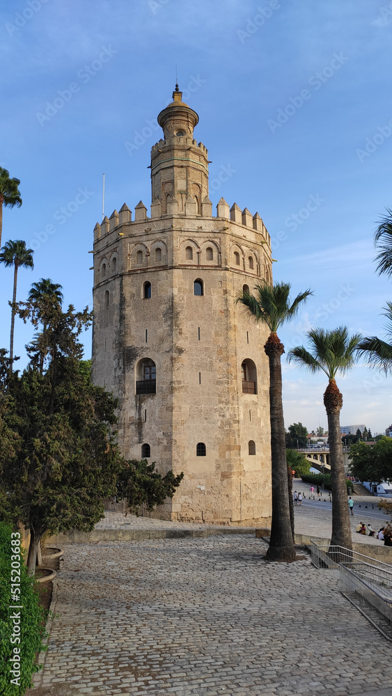 Seville, Spain, September 12, 2021: The Tower of Gold at the Quidalquivir in Sevilla. The Golden Tower is one of Seville's iconic landmarks. La Torre del Oro is a military observation tower.