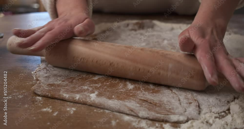 Hands using rolling pin to roll out cookie dough. Close up, gimbal Hands using rolling pin to roll out cookie dough. Close up, gimbal