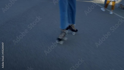 Close view of legs of girl doing tricks on roller skates on street photo