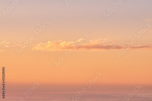 Seascape copy space with clouds in an orange sunset sky with a copyspace background. Calm  serene  tranquil  peaceful and zen ocean and sea view at dusk. Beautiful scenic mother nature in the evening