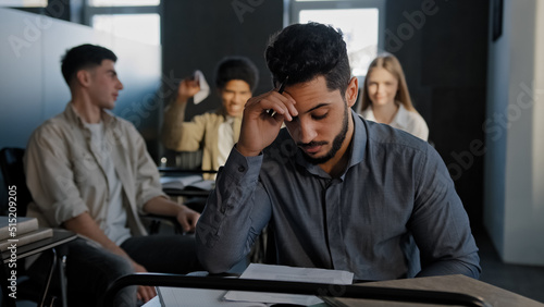 Tableau sur toile Frustrated oppressed indian student sitting in class lonely young guy suffers fr