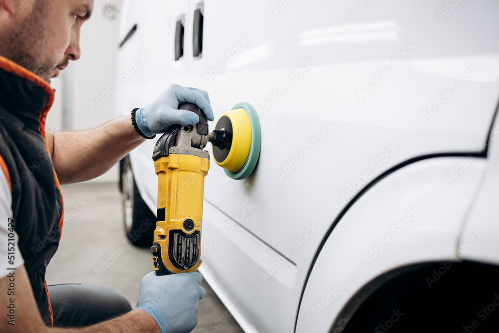 Car detailing - Hands with orbital polisher in auto repair shop. Selective focus. Car detailing - Hands with orbital polisher in auto repair shop. Selective focus.