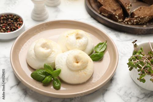 Delicious burrata cheese with basil on white marble table
