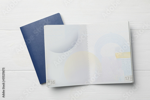 Blank passports on white wooden table, flat lay photo