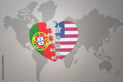 puzzle heart with the national flag of portugal and liberia on a world map background.Concept.