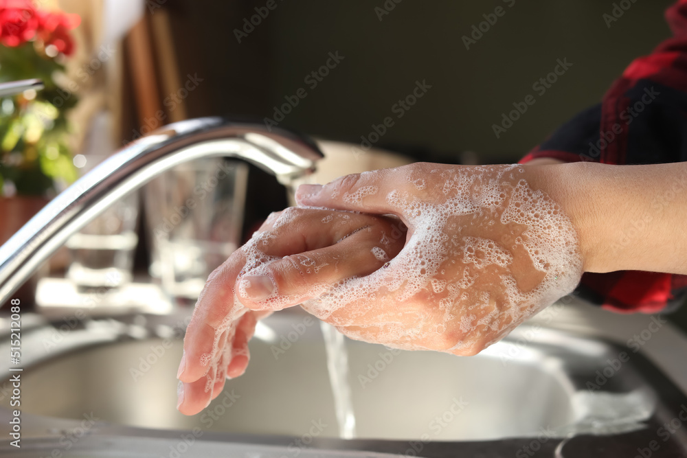 Woman washing hands in kitchen, closeup view Woman washing hands in kitchen, closeup view