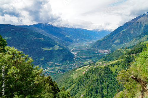 a hiking trail overlooking the alpine valley of the city Merano surrounded by the Texel group mountains (Oetztaler Alpen in Südtirol, South Tyrol, Italy) 