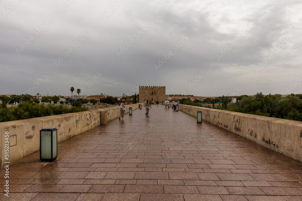 Obraz premium Cordoba, Spain, September 13, 2021: The defensive tower from the Muslim era: the Calahorra Tower, Guadalquivir River, and the Roman Bridge.
