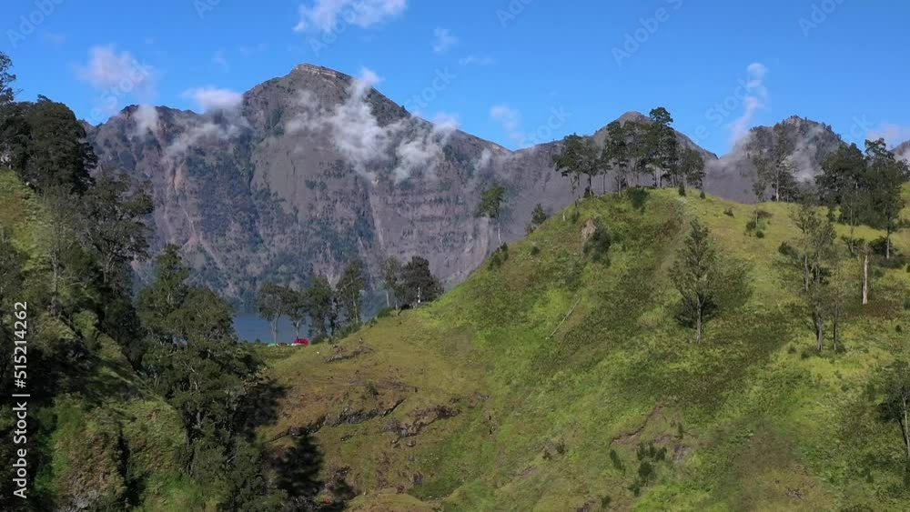 Trapped clouds in the crater lake of Mount Rinjani active volcano in Indonesia, Aerial dolly left reveal shot Trapped clouds in the crater lake of Mount Rinjani active volcano in Indonesia, Aerial dolly left reveal shot