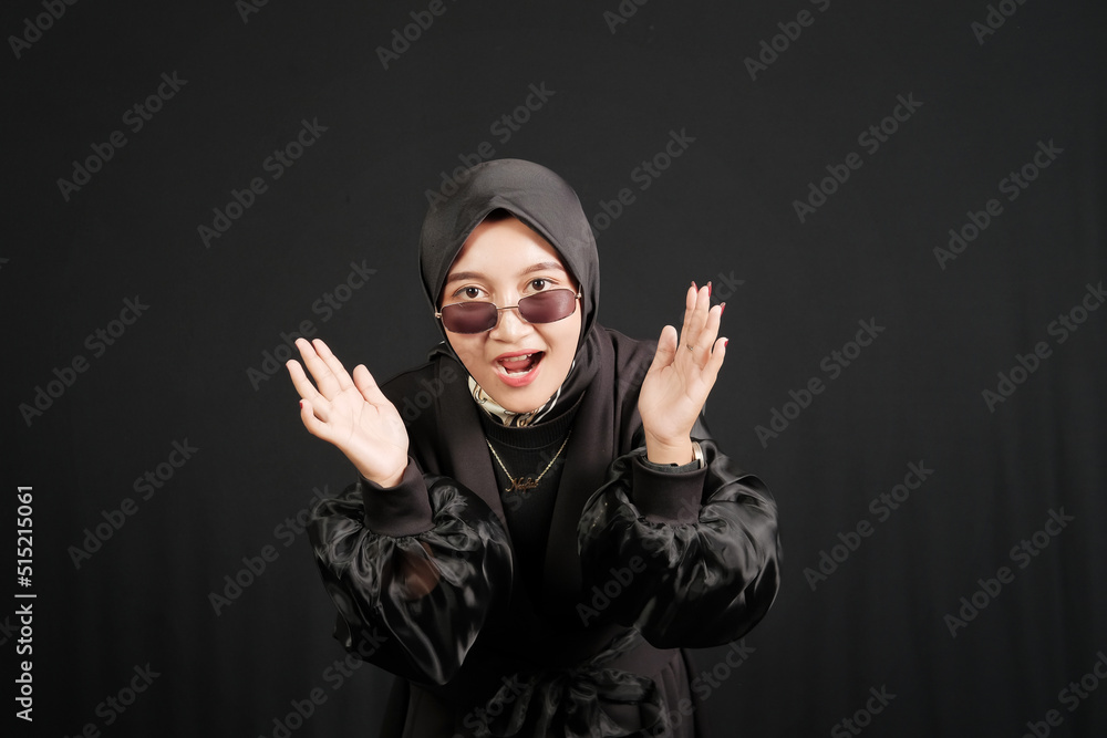 Happy young Asian Muslim woman wearing glasses isolated on black background. Happy young Asian Muslim woman wearing glasses isolated on black background.